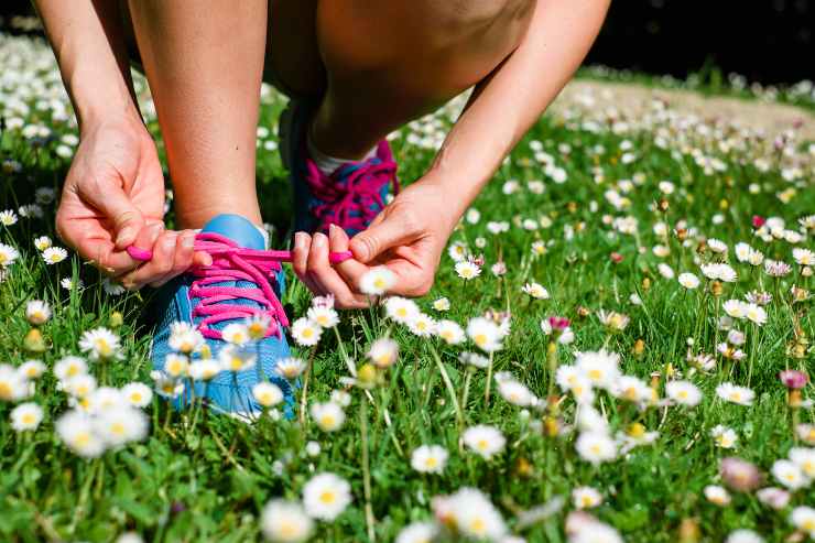 Donna allaccia le scarpe in un prato