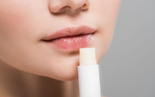 Donna che si mette del balsamo labbra