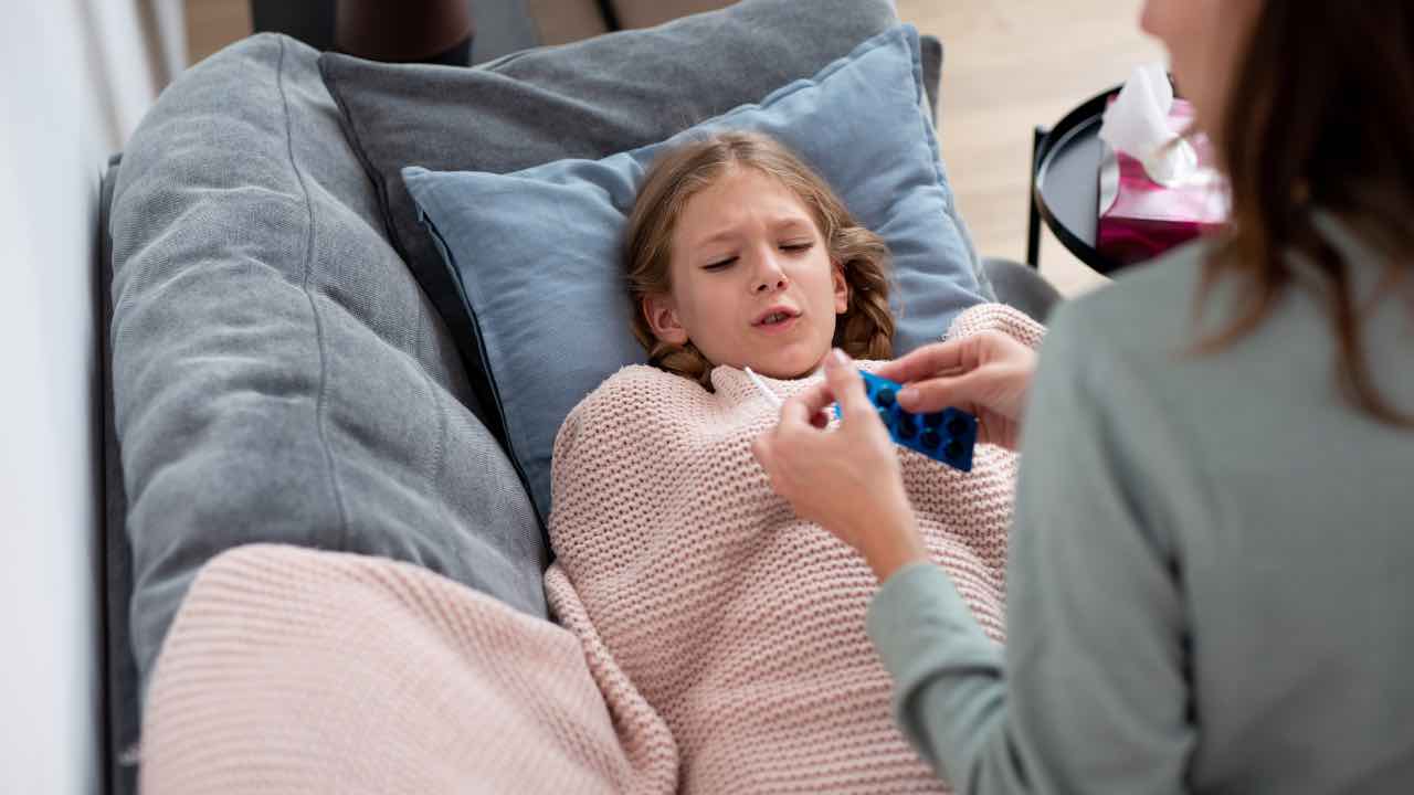 Bambina che si misura la febbre 