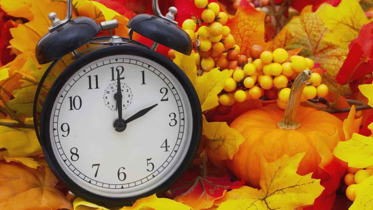 Orologio con foglie d’autunno come sfondo 